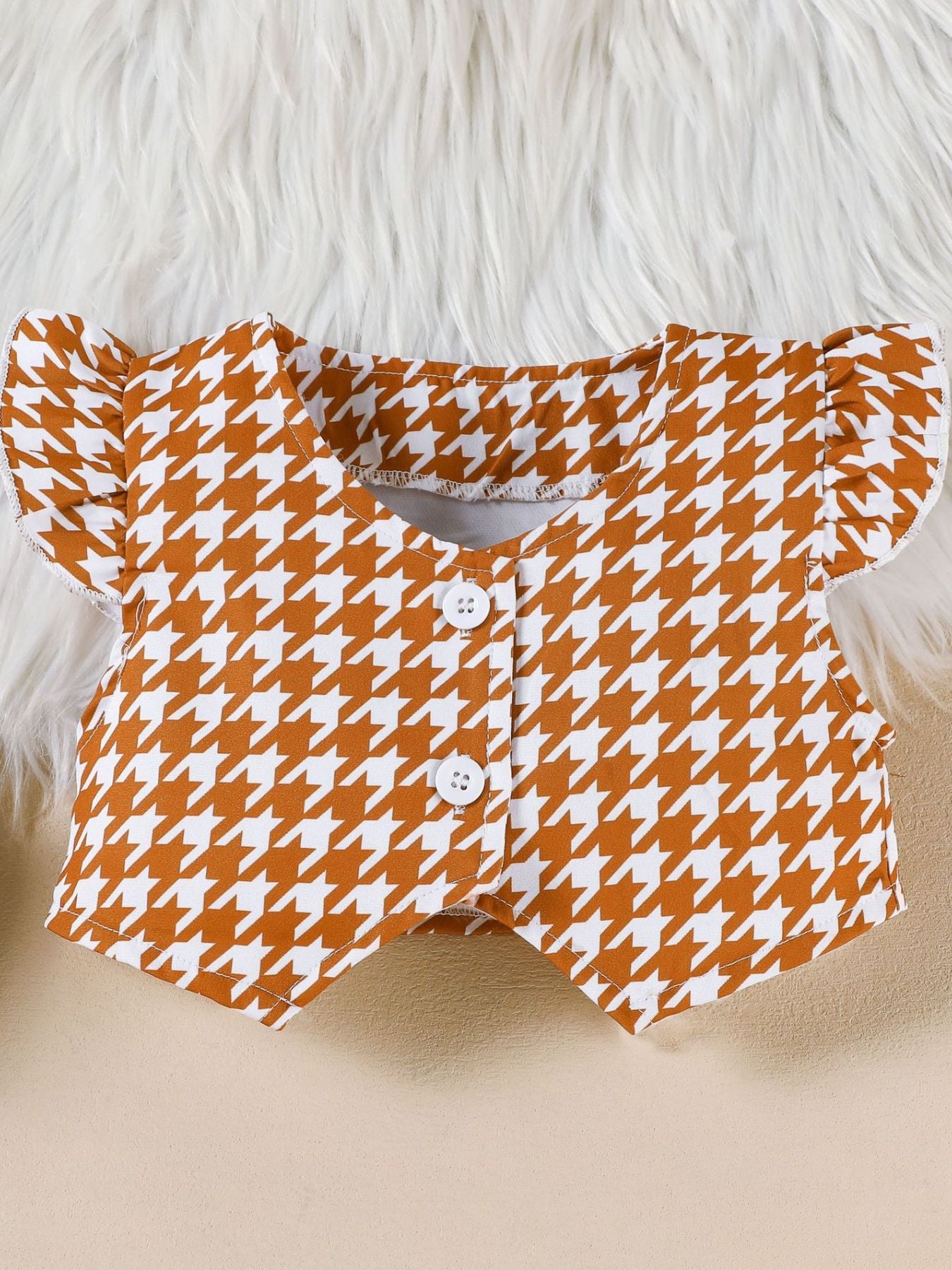 Toddler vest with houndstooth pattern, flutter sleeves, and button front.