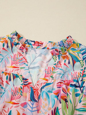 Tropical floral print cotton blouse with ruffled V-neck and short sleeves.