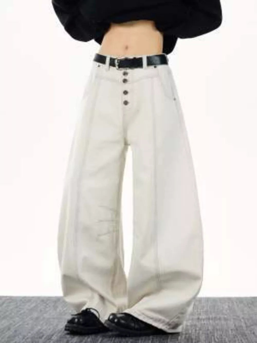 Relaxed fit wide leg button-fly jeans in off-white cotton with contrast stitching and a black belt.