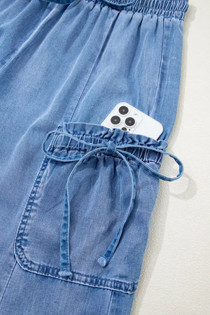 Light wash denim maternity cargo jeans with drawstring waist and cinched cargo pocket.