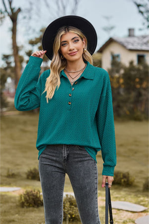 Turquoise textured knit polo shirt with button detail and long sleeves.
