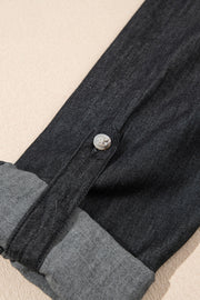 Relaxed black denim shirt with buttoned cuff detail and rolled sleeves.