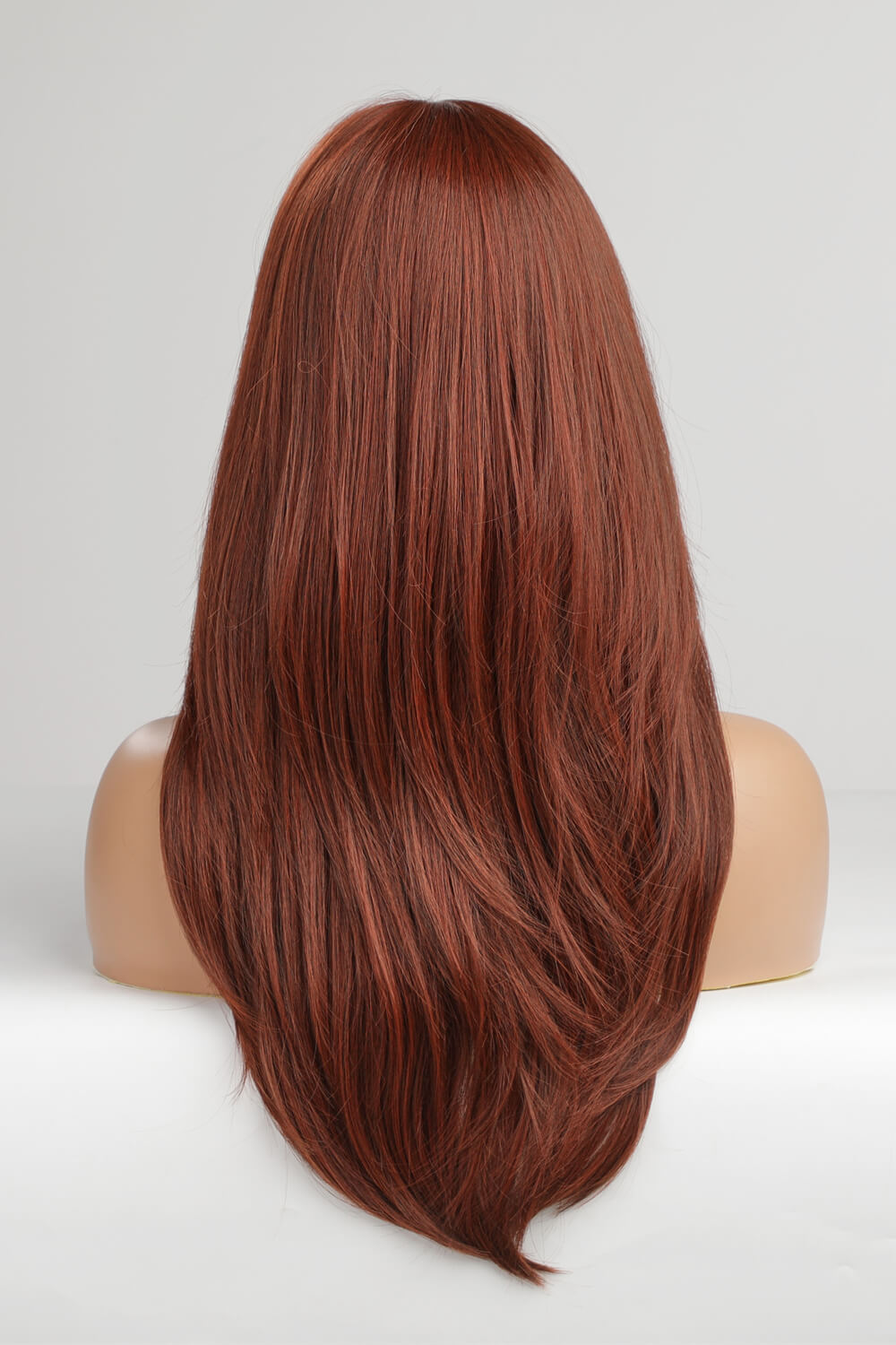 Layered copper red synthetic wig with subtle highlights and a straight cut.