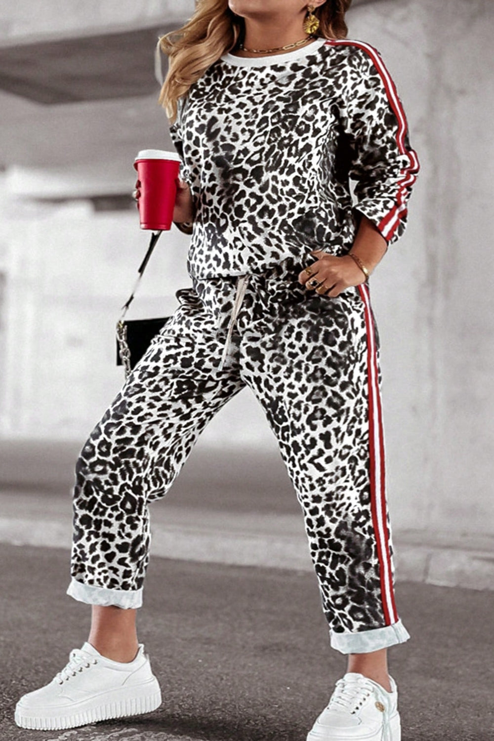 Leopard print joggers with sporty red and white side stripes and drawstring waist.