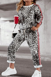 Leopard print joggers with sporty red and white side stripes and drawstring waist.