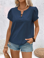 Indigo linen blouse with mandarin collar, puff sleeves, and knot button detail.