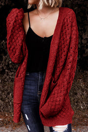 Textured open-knit pocket cardigan in deep red acrylic with cable knit sleeves.