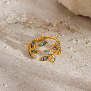 Gold bypass ring with delicate leaf design featuring iridescent blue and purple inlay.