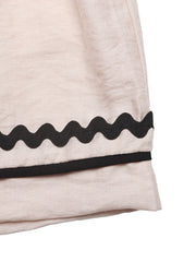 Beige shorts with elastic waist and wavy black trim detail