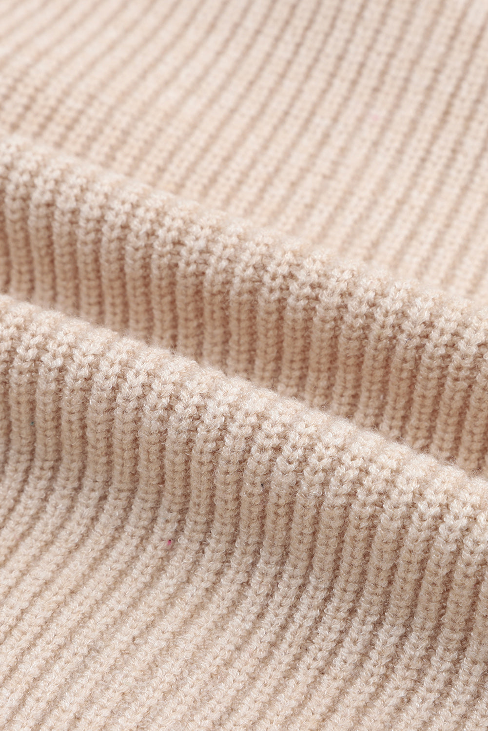 Beige ribbed knit cardigan with a shawl collar, showing fabric texture.
