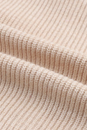 Beige ribbed knit cardigan with a shawl collar, showing fabric texture.