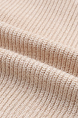 Beige ribbed knit cardigan with a shawl collar, showing fabric texture.