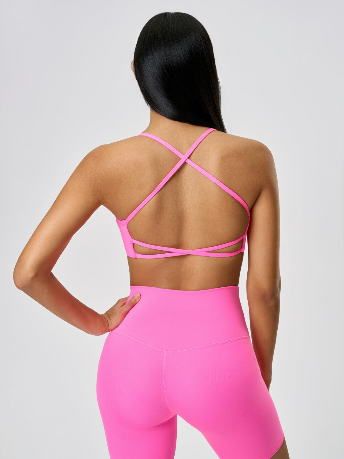 Fuchsia pink active crop top with strappy back detail.