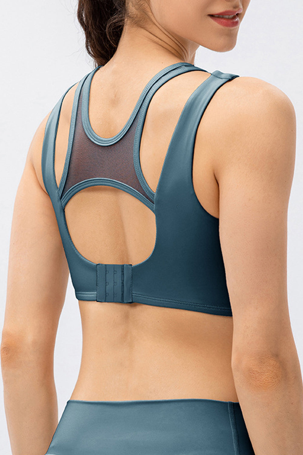 Mesh inset performance bra top in dark blue with cutout back detail and adjustable clasp