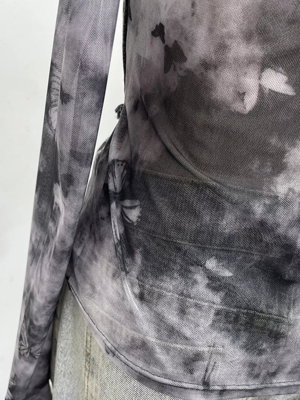 Edgy asymmetrical t-shirt in gray black tie-dye mesh with butterfly print and denim accents.