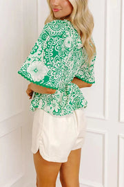 Green floral smocked v-neck polyester overshirt with ruffled sleeves and hem