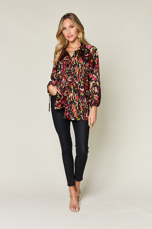 Silk tie-neck blouse with abstract floral print and button closure.