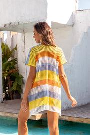 Rainbow crochet beach cover-up with short sleeves and a V-neck in yellow, orange, white, and blue stripes.