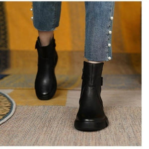 Black round toe ankle boots with decorative buckle detail and side zipper.