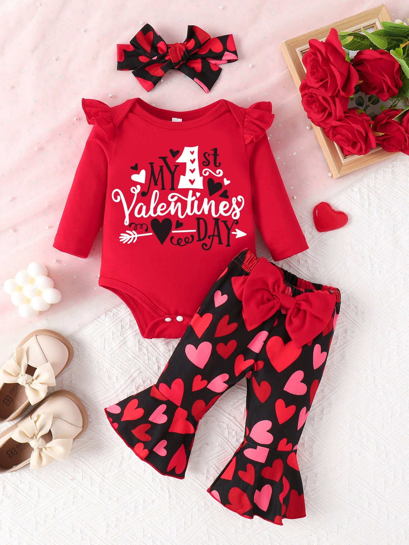 Red baby bodysuit with ruffles and heart print bell-bottom pants set.