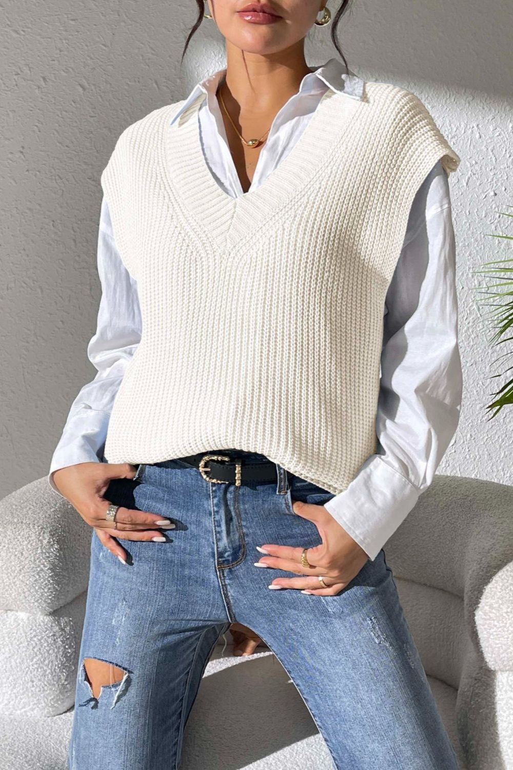 Ivory textured knit V-neck sleeveless top over a white button-down shirt.