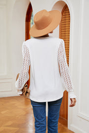 White knit blouse with lace sleeves and smocked cuffs.