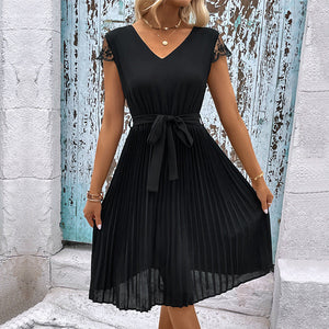 Black midi dress with tie belt, lace cap sleeves, and pleated skirt.