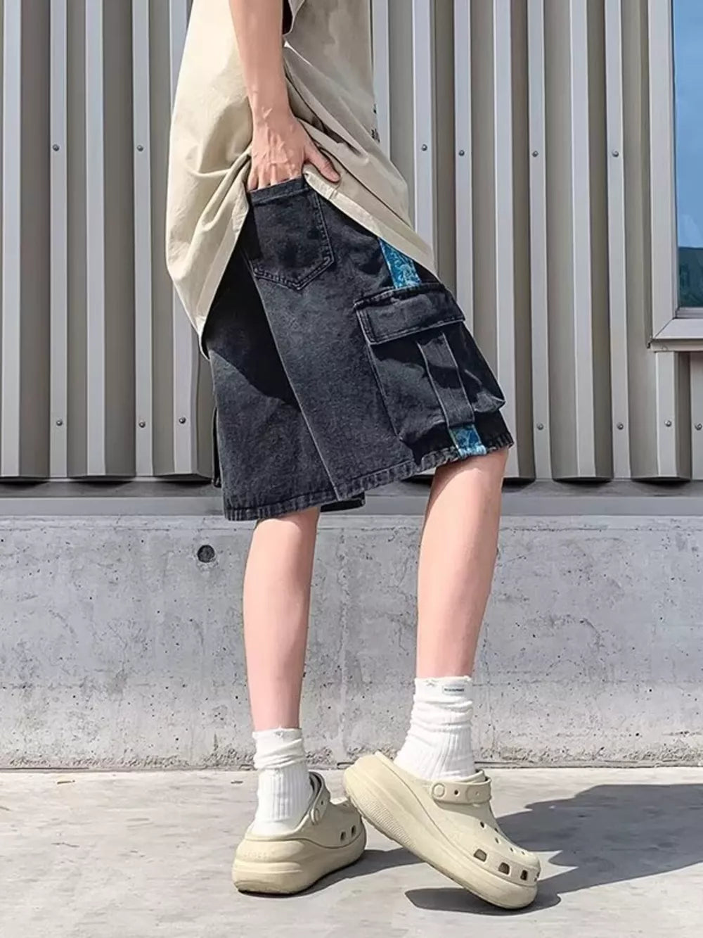 Black denim cargo shorts with braided drawstring and blue side stripe detail.