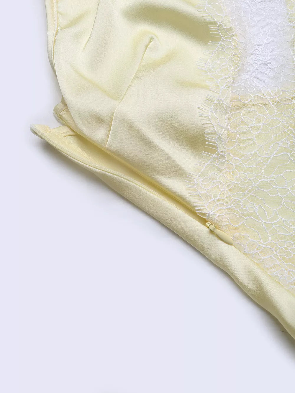 Lace-trimmed midi slip dress in pale yellow satin with side zipper detail.