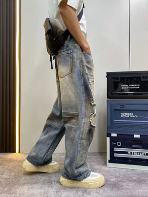 Heavily distressed vintage wide-leg jeans in blue denim with ripped details.
