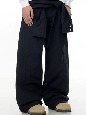 Black wide-legged cargo pants with a tie waist and buttoned cuffs.