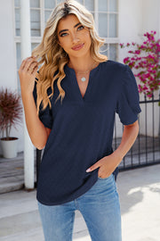 Dark blue eyelet V-neck blouse with puff sleeves and a casual fit.