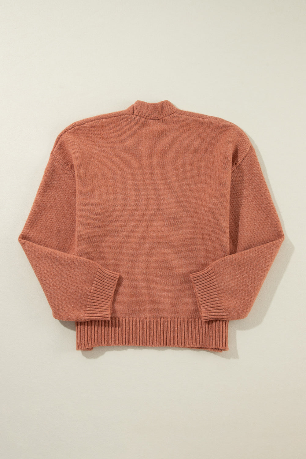 Open-front cropped knit cardigan in burnt coral acrylic with ribbed cuffs and hem.