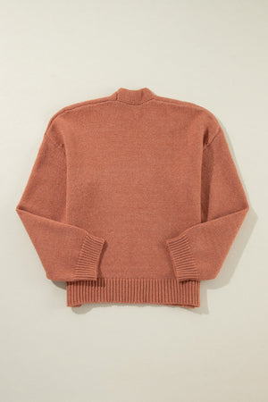 Open-front cropped knit cardigan in burnt coral acrylic with ribbed cuffs and hem.