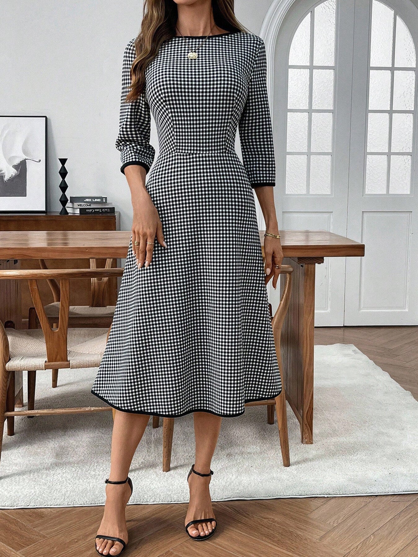 Black and white gingham midi dress with 3/4 sleeves, a-line cut, and contrast trim.