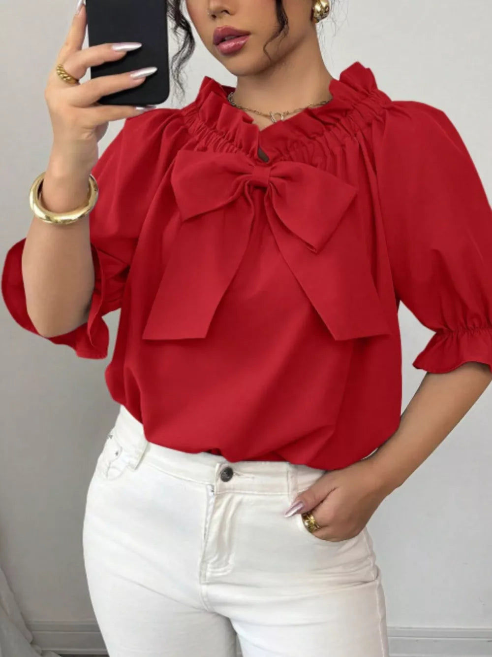 Red ruffled bow sleeve blouse with cinched neckline and puff sleeves.