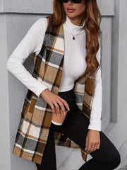 Tartan longline vest in camel with a buttoned front, worn over a white turtleneck and black pants.