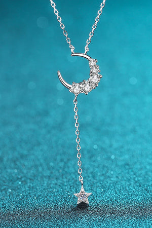 Silver celestial pendant necklace with crescent moon and star charms.