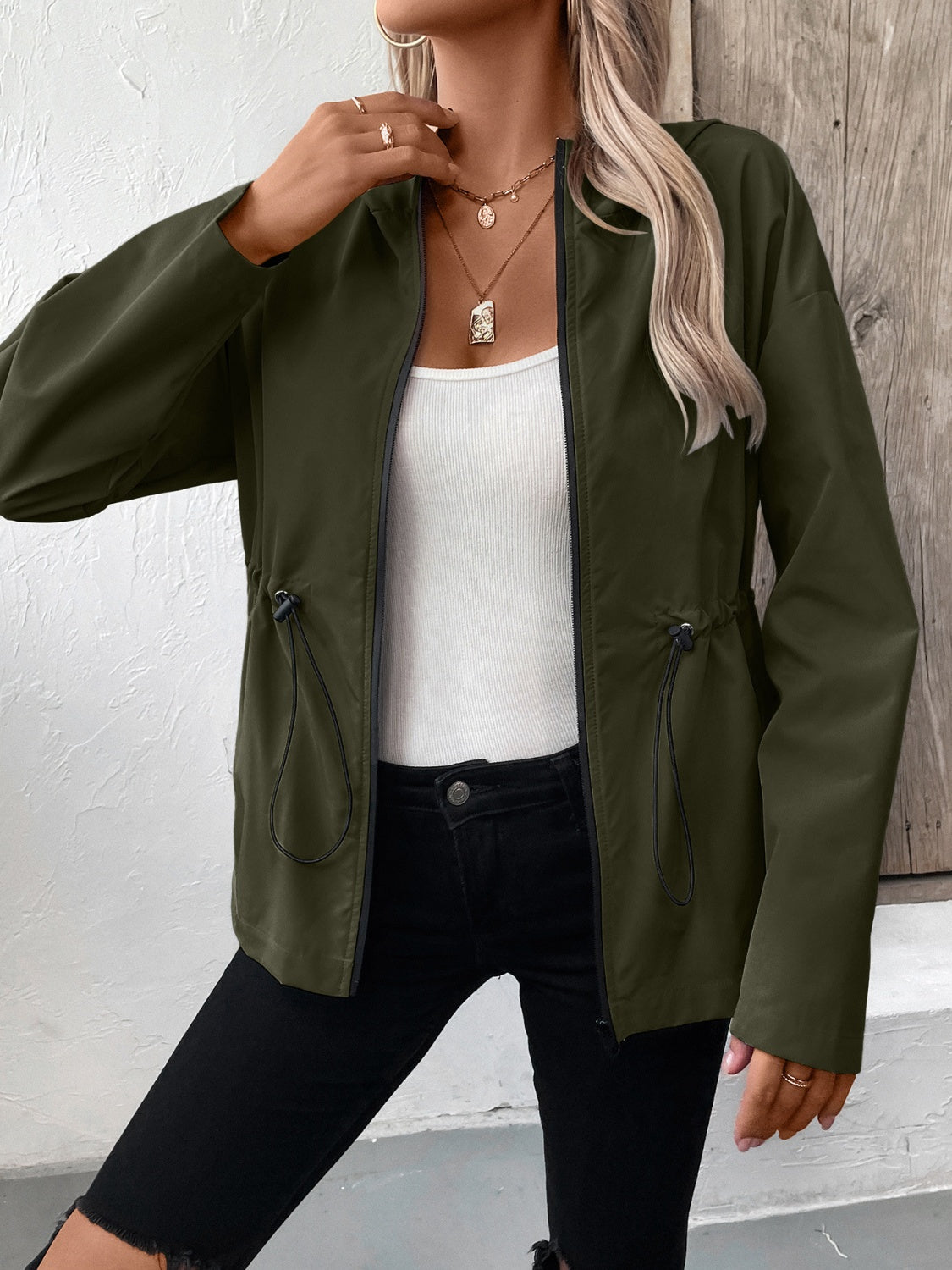 Army green utility jacket with cinched waistline and black trim.