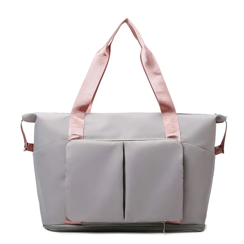 Gray foldable travel tote with pink straps and exterior pockets