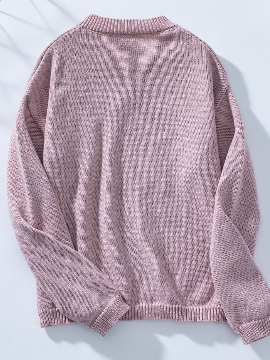 Dusty pink knit sweater with notched neckline and ribbed cuffs and hem.