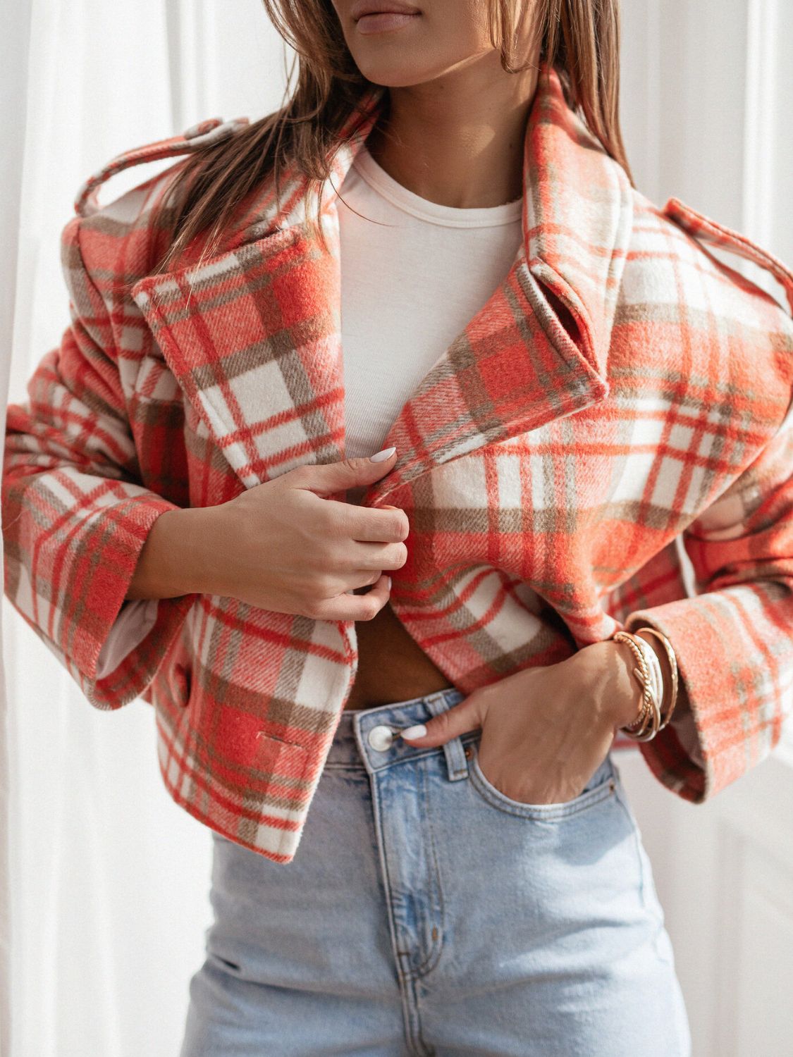 Boxy plaid cropped blazer in orange with a white and brown pattern, featuring a notched collar and button front.