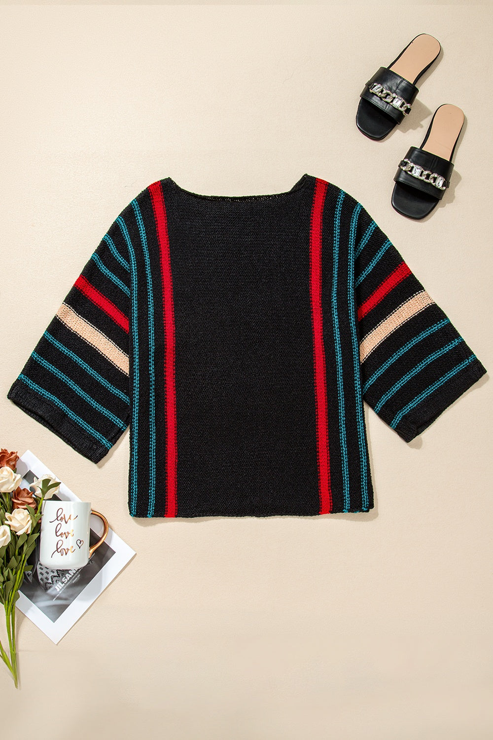 Black knit pullover with red, blue, and tan striped sleeves and side panels.