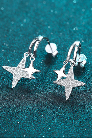 Silver drop earrings with celestial starburst charms, one star is paved with crystals.