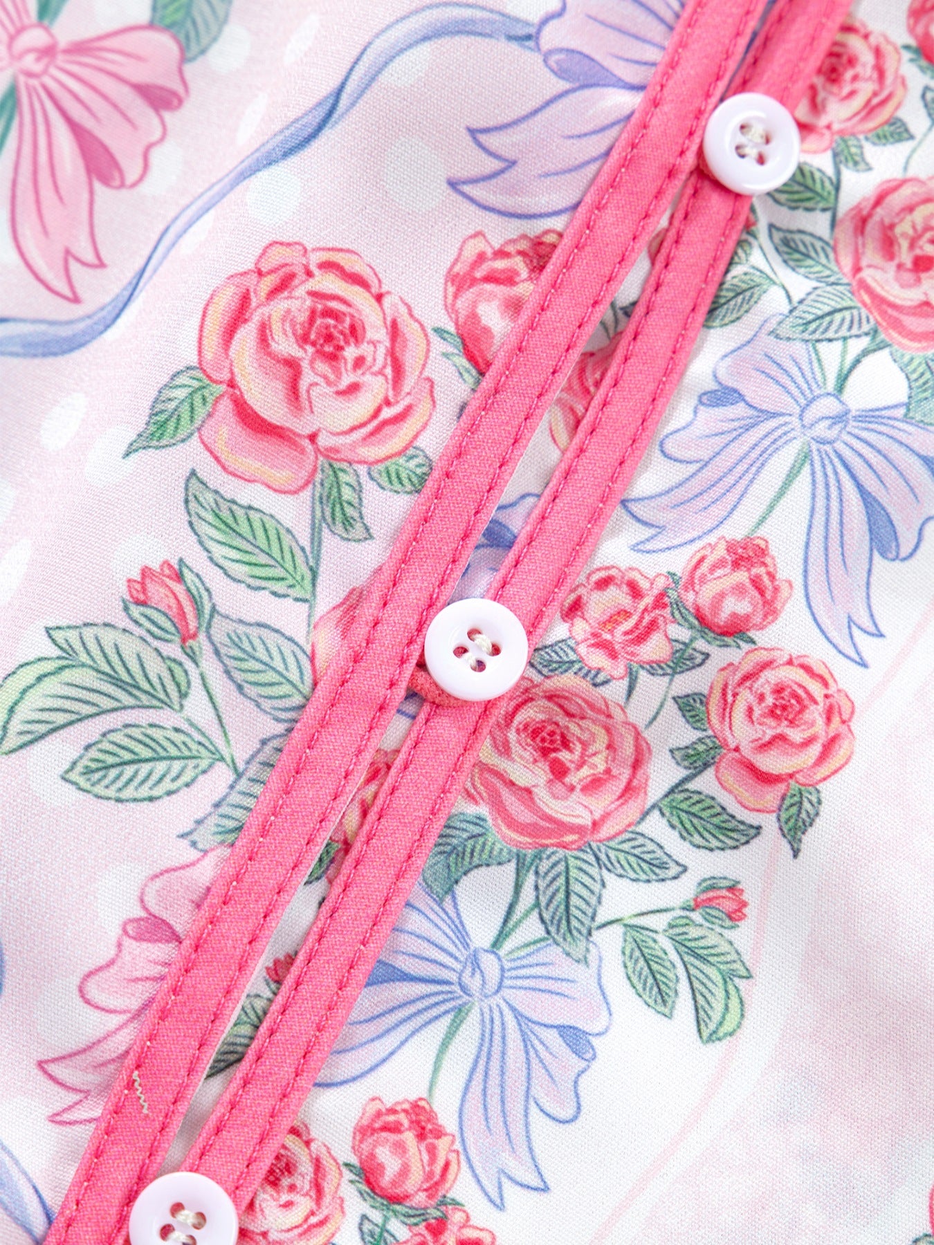 Maternity shirt with pink roses and blue bows pattern, button-up front with white buttons.