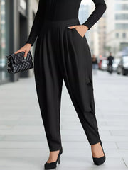 Black ribbed maternity pants with a relaxed fit and pockets, styled with heels and a clutch.