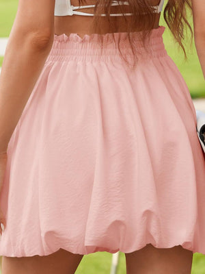 Blush pink bubble hem mini skirt with smocked waist and textured fabric.