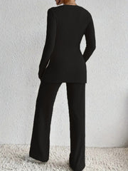 Black ribbed knit lounge set with long sleeves and flared pants.