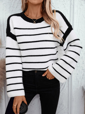 Black and white striped knit sweater with wide sleeves and contrast black shoulder details.