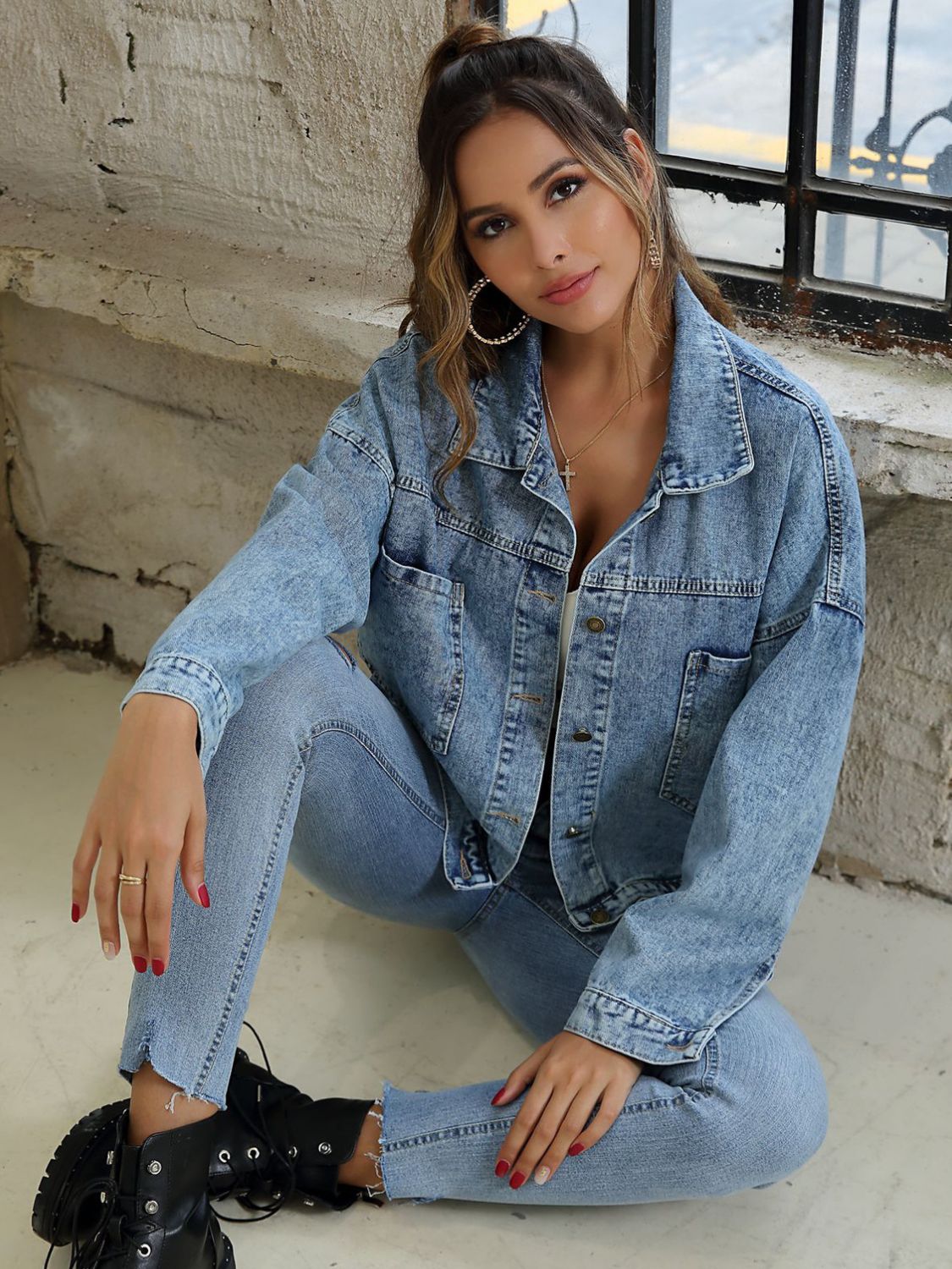 Oversized light wash denim jacket with buttoned patch pockets and a classic collar.
